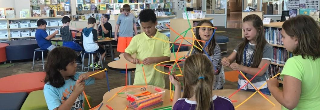 Students build structures in teams using straws and connectors.